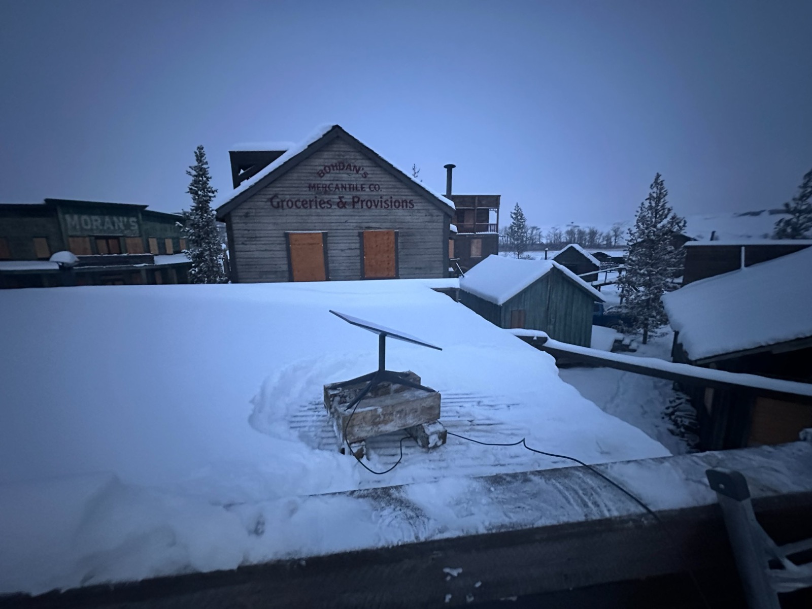 Starlink dish on rooftop of snowy western film set town